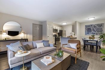 A living room with a couch and a table and a kitchen