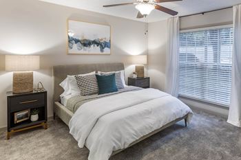 A bedroom with a bed and a ceiling fan