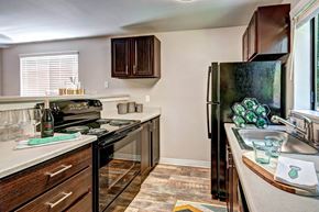 Edmonds apartment for rent - A kitchen with a black refrigerator and wooden cabinets at Brackett Apartments, Edmonds, WA, 98020