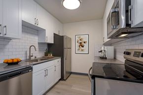 San Francisco apartment for rent - a kitchen with stainless steel appliances and white cabinets at Delphine on Diamond, California, 94131