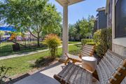 Pearland apartment for rent - a porch with two chairs and a table and a playground in the background at Sladestone Shadow Creek, Pearland, TX, 77584