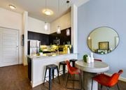 Dallas apartment for rent - a kitchen with a bar and stools and a round table at South Side Flats, Dallas, TX