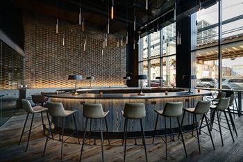 A bar with a brick wall and wooden chairs.