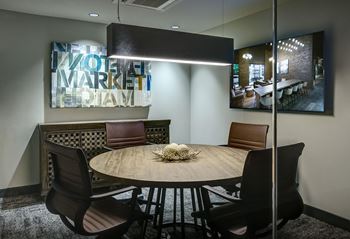 A conference room with a round table and chairs.