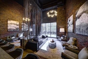 Chicago apartment for rent - A living room with a black couch and a large window.