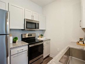 The Woodlands apartment for rent - a kitchen with stainless steel appliances and white cabinets at Volare at the Woodlands, The Woodlands, TX