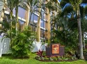 Wahiawa apartment for rent - a sign in front of Palms of Kilani with palm trees at Palms of Kilani Apartments, Wahiawa, HI 96786
