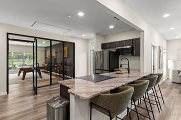 Greenville apartment for rent - A modern kitchen with a marble countertop and a dining table with chairs.