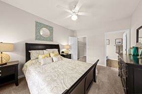 Greenville apartment for rent - A bedroom with a large bed and a ceiling fan.