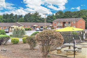 Thomasville apartment for rent - A sunny day at a residential complex with a playground and picnic tables.
