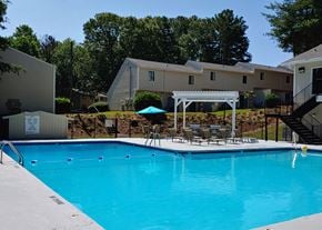 Winston-Salem apartment for rent - a large swimming pool with tables and chairs next to a building