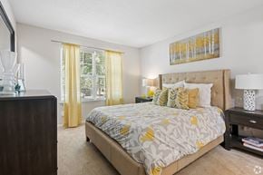Winston-Salem apartment for rent - A bedroom with a bed, nightstand, and a painting on the wall.