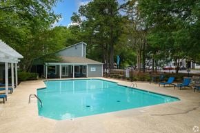 Winston-Salem apartment for rent - A small pool surrounded by trees and a building.