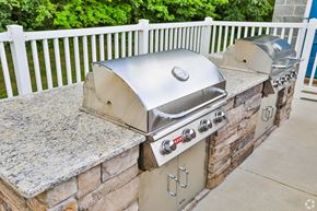 Monroe apartment for rent - A silver BBQ grill on a stone and concrete patio.