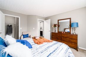 Reynoldsburg apartment for rent - A bedroom with a bed, dresser, mirror, and lamp. at Estates at Brentwood Lake Apartments, Ohio