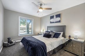 Grand Rapids apartment for rent - the master bedroom has a large bed and a ceiling fan