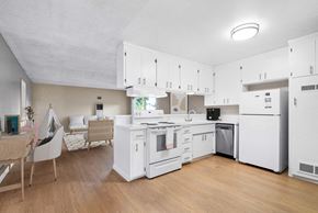 Santa Cruz apartment for rent - a kitchen with white cabinets and appliances and a dining table