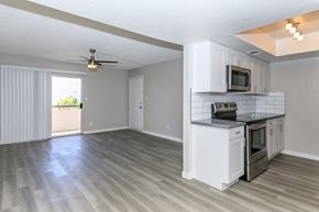 Mesa apartment for rent - an empty kitchen and living room with a ceiling fan at Saltéra Apartments, Mesa, Arizona 85204
