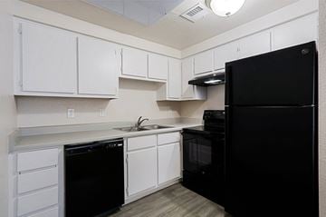 Yuma apartment for rent - a kitchen with black appliances and white cabinets