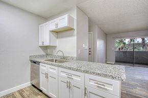 Phoenix apartment for rent - A kitchen with white cabinets and granite countertops.
