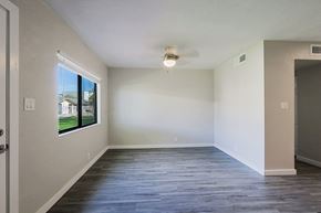 Phoenix apartment for rent - A spacious room with a ceiling fan and a window overlooking a building.