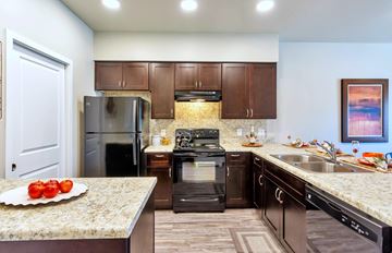 Phoenix apartment for rent - a kitchen with dark wood cabinets and granite countertops