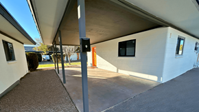 Phoenix apartment for rent - a side view of a white building with a driveway and a parking meter