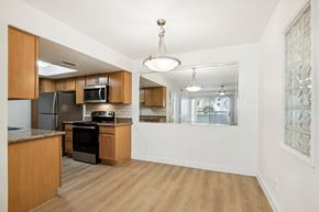 Scottsdale apartment for rent - A kitchen with wooden cabinets and a black stove top oven. at The Viridian, Scottsdale