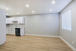 Phoenix apartment for rent - an empty living room with a kitchen with white cabinets and a window