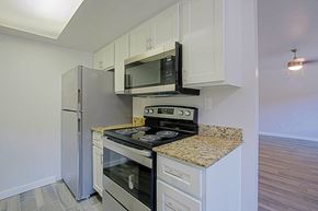 Mesa apartment for rent - A kitchen with a granite countertop and stainless steel appliances at Aspire Mesa, Mesa, 85210.