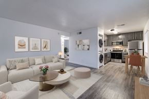 Phoenix apartment for rent - A modern living room with a white couch, a coffee table, and a dining table.