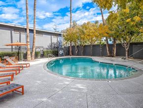 Tempe apartment for rent - a swimming pool with benches and trees next to a building