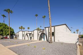 Phoenix apartment for rent - a white brick building with palm trees and a blue sky
