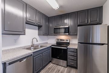 Phoenix apartment for rent - A kitchen with dark cabinets and stainless steel appliances.
