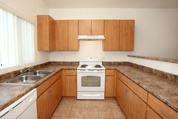 Surprise apartment for rent - A kitchen with a stove, sink, and cabinets.