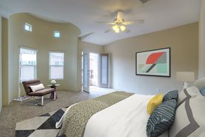 Phoenix townhouse for rent - a bedroom with a bed and a chair and a ceiling fan