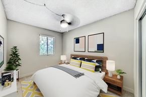 Phoenix townhouse for rent - A bedroom with a bed, nightstand, and a plant at Connect on Missour Apartments, Phoenix, Arizona