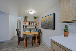 Glendale apartment for rent - A dining room with a round table and chairs, a bookshelf, and a painting on the wall at Connect on Northern, Glendale, AZ 85301