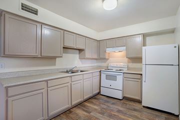 Phoenix apartment for rent - A kitchen with white appliances and wooden cabinets.