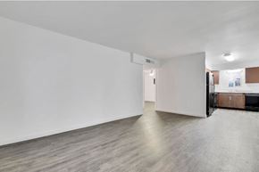 Tempe apartment for rent - an empty living room with white walls and a refrigerator