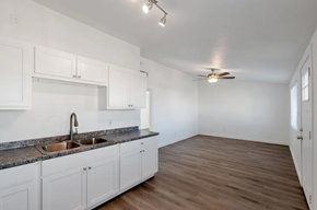 Phoenix apartment for rent - a kitchen and living room with white cabinets and a ceiling fan