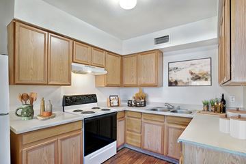 Phoenix apartment for rent - A kitchen with wooden cabinets and a black stove top oven.