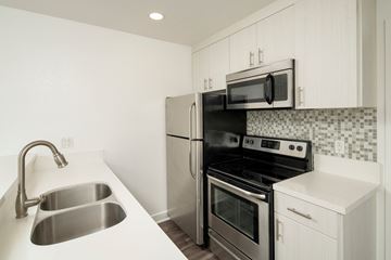 Phoenix apartment for rent - A kitchen with a stainless steel sink and black appliances.