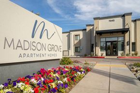 Phoenix apartment for rent - The entrance to Madison Grove Apartment Homes is shown with a sign and a flower bed.