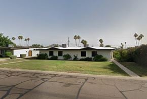Scottsdale apartment for rent - A white house with a green lawn in front.