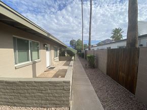 Phoenix apartment for rent - A residential area with a house, a fence, and a tree.