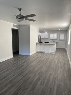 Phoenix apartment for rent - an empty living room with a kitchen and a ceiling fan