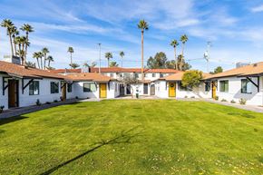 Phoenix apartment for rent - a group of houses with a green lawn and palm trees