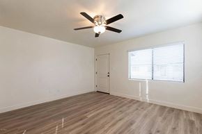 Phoenix apartment for rent - an empty living room with a ceiling fan and a window