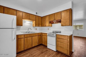 Phoenix apartment for rent - A kitchen with wooden cabinets and white appliances.